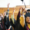 Senior high school students toss their caps at graduation.