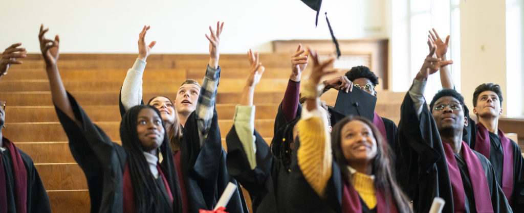Senior high school students toss their caps at graduation.