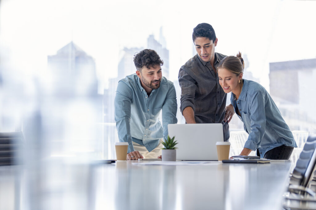 Corporate operations team working on laptop at conference table