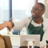 Young barista uses his employability skills to serve a customer.