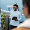 Man practices oral communication by presenting at a business meeting